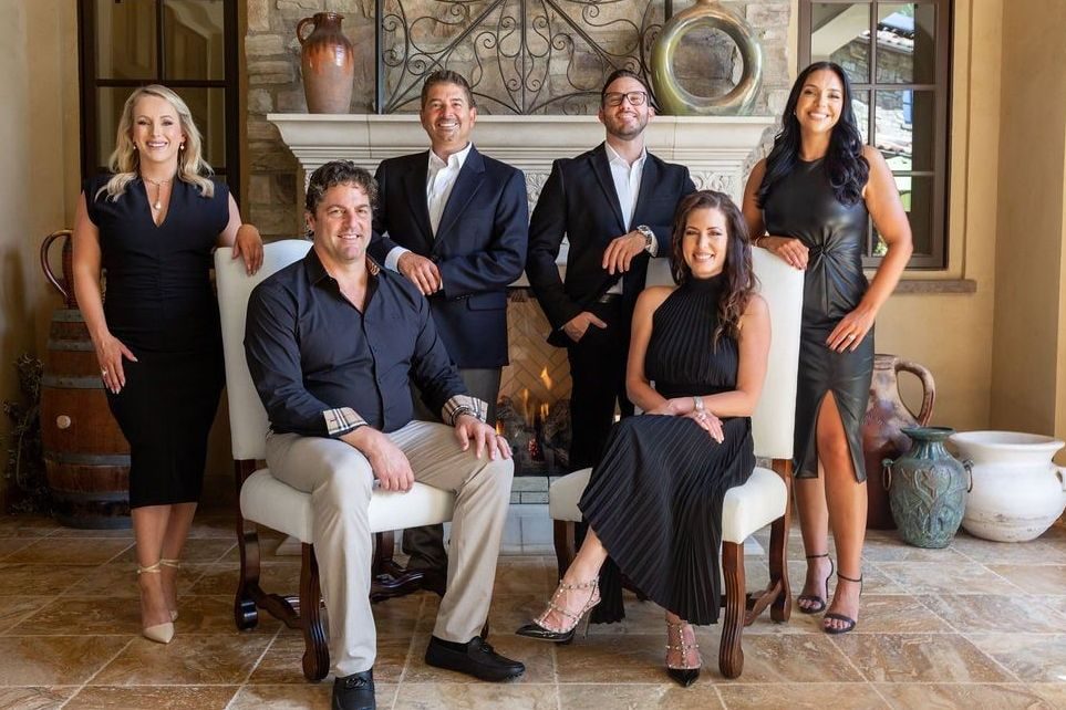 Group of six real estate agents posing in a living room